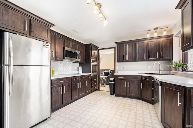 kitchen with light floors, a sink, stainless steel appliances, dark brown cabinetry, and light countertops