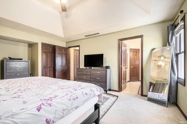 bedroom featuring visible vents, light carpet, a raised ceiling, a closet, and baseboards