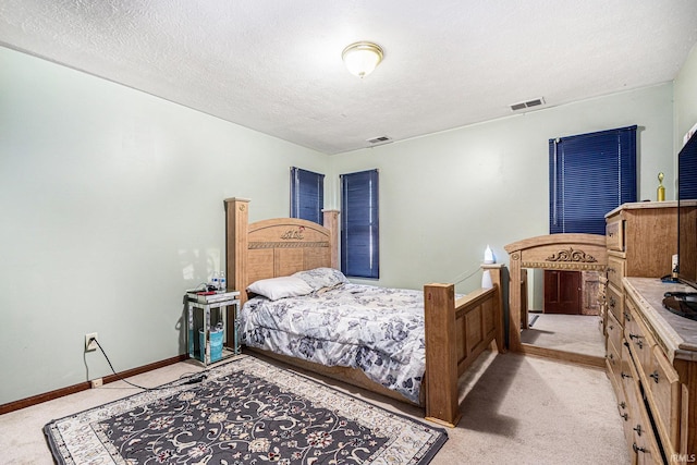 bedroom with visible vents, light carpet, a textured ceiling, and baseboards