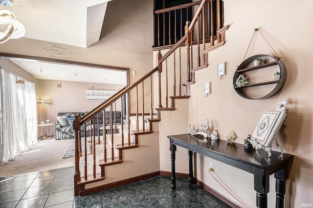 stairway with baseboards and carpet floors