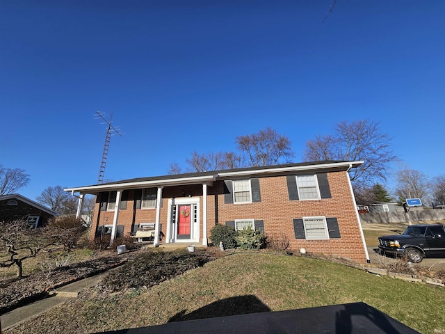 split foyer home featuring brick siding and a front yard