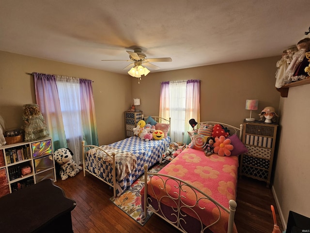 bedroom with hardwood / wood-style floors, a ceiling fan, and baseboards