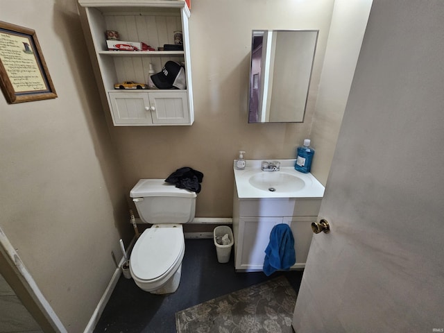 bathroom with baseboards, toilet, and vanity