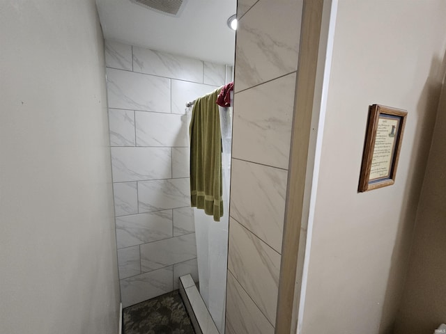 full bathroom with a tile shower and visible vents