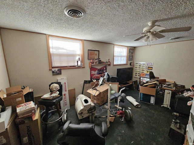 interior space with visible vents, a textured ceiling, and ceiling fan