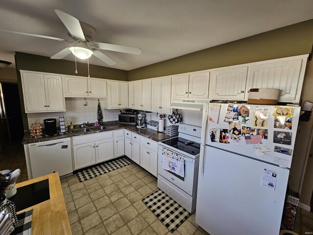 kitchen with a sink, dark countertops, white cabinetry, white appliances, and decorative backsplash