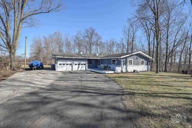 view of front of property with aphalt driveway, a garage, and a front lawn