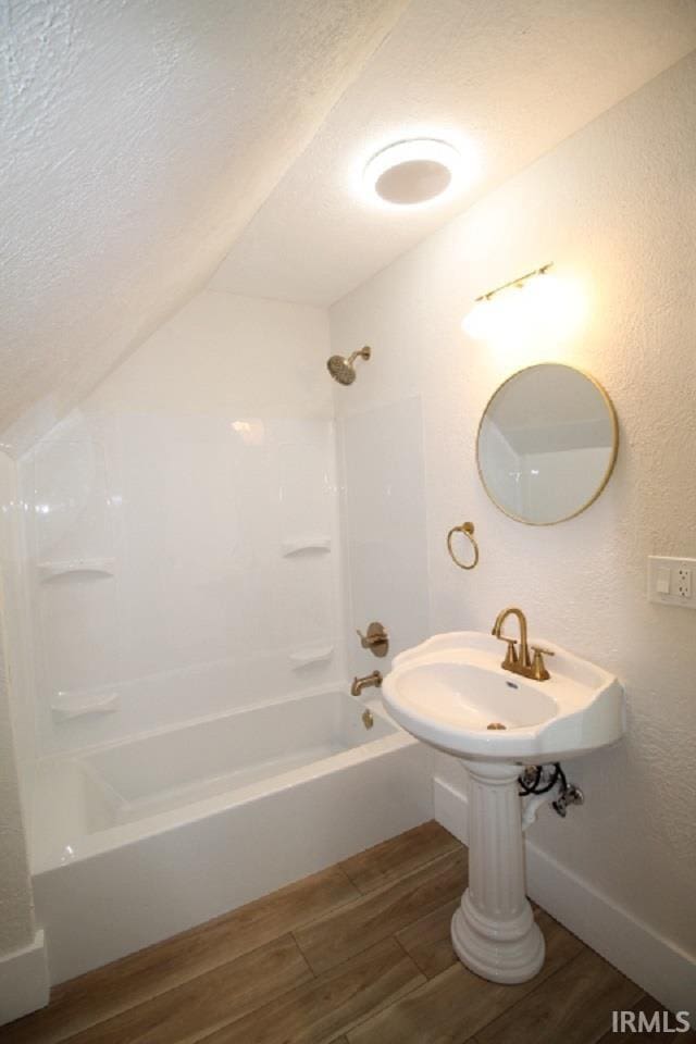 full bath with a textured ceiling, bathtub / shower combination, and wood tiled floor