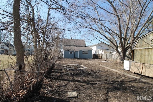 exterior space with an outbuilding, fence, and an exterior structure