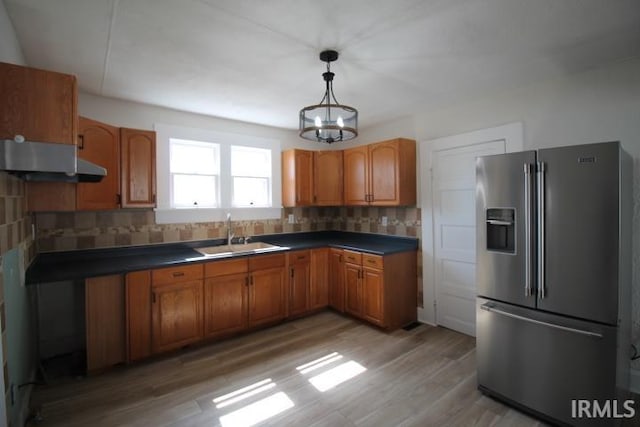 kitchen with tasteful backsplash, a sink, a chandelier, and stainless steel fridge with ice dispenser