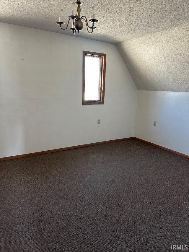 bonus room featuring baseboards, lofted ceiling, a textured ceiling, and carpet flooring