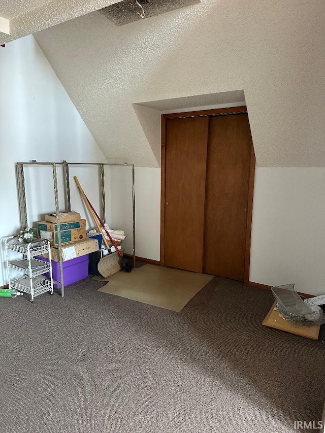 bonus room with carpet floors, a textured ceiling, and vaulted ceiling