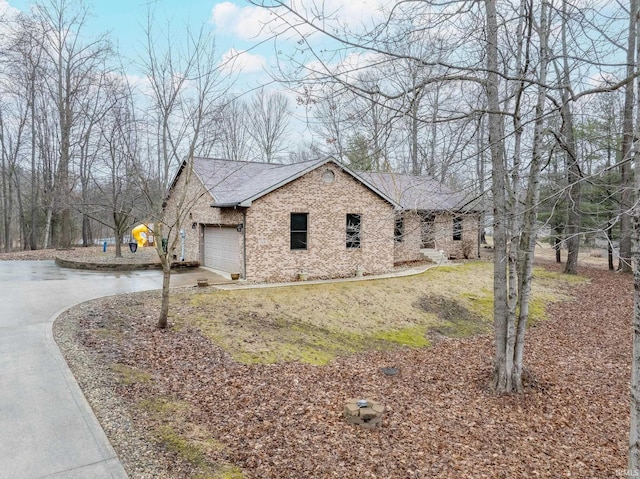 view of property exterior featuring brick siding, concrete driveway, a garage, and a shingled roof