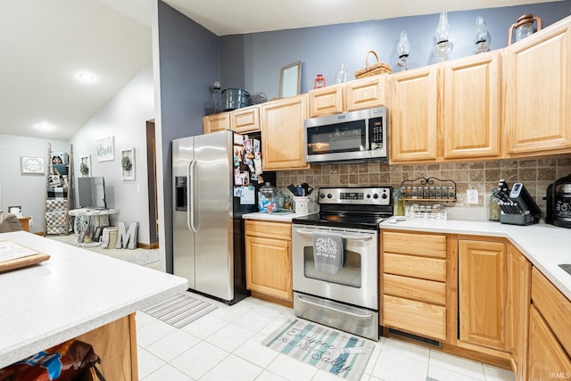 kitchen featuring light brown cabinets, appliances with stainless steel finishes, and light countertops