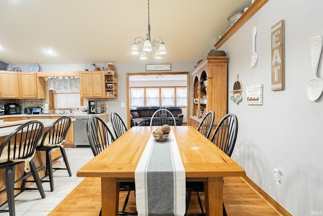 dining space with light tile patterned flooring and an inviting chandelier