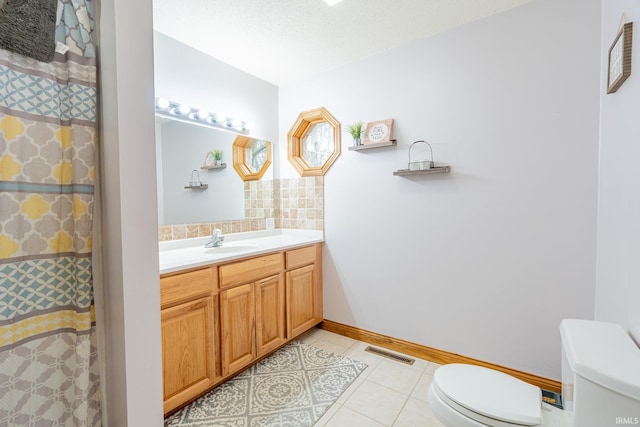 bathroom featuring tile patterned flooring, visible vents, baseboards, toilet, and vanity