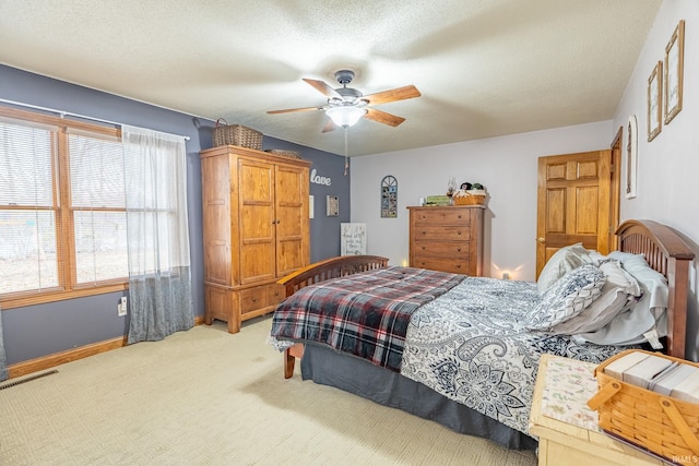 bedroom featuring visible vents, a ceiling fan, a textured ceiling, carpet flooring, and baseboards