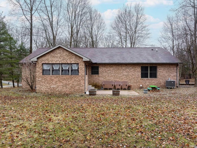 back of house with central AC unit, a patio area, and brick siding