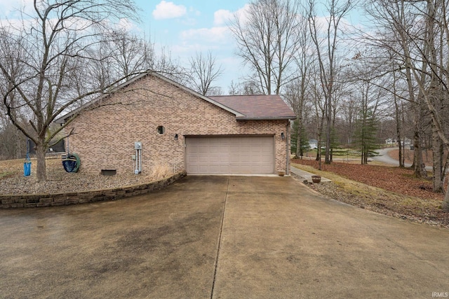 view of side of home featuring brick siding, an attached garage, driveway, and roof with shingles