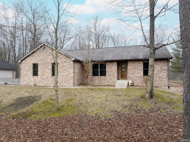 single story home with brick siding, roof with shingles, an outdoor structure, and a front lawn