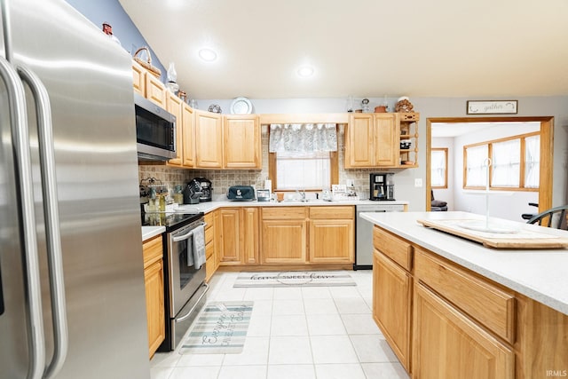 kitchen featuring light brown cabinetry, a sink, appliances with stainless steel finishes, light countertops, and decorative backsplash