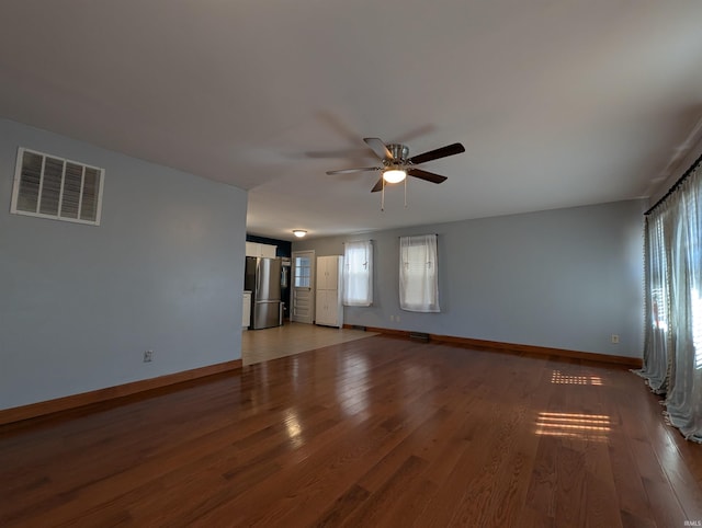 spare room featuring light wood-type flooring, visible vents, plenty of natural light, and baseboards