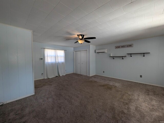 spare room with carpet floors, a ceiling fan, and a wall unit AC