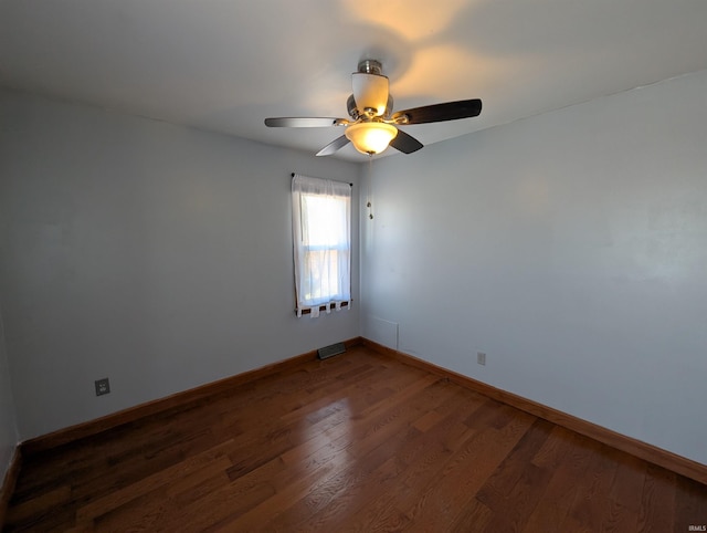 unfurnished room featuring a ceiling fan, visible vents, dark wood-style floors, and baseboards