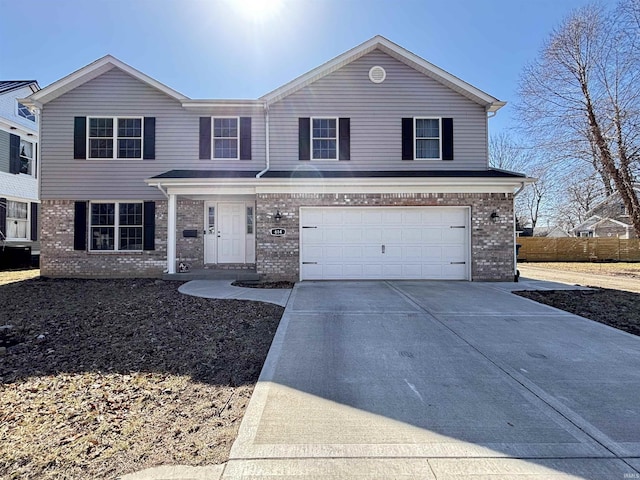 traditional home with concrete driveway, an attached garage, and brick siding