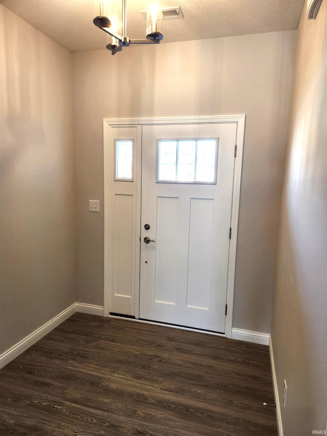 entrance foyer with dark wood-style floors, an inviting chandelier, and baseboards