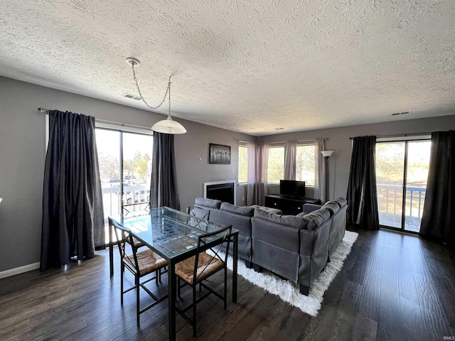 dining space featuring baseboards, plenty of natural light, visible vents, and dark wood finished floors