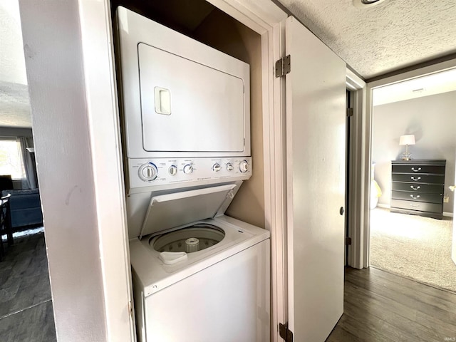 washroom with dark wood-style floors, laundry area, a textured ceiling, and stacked washer and dryer