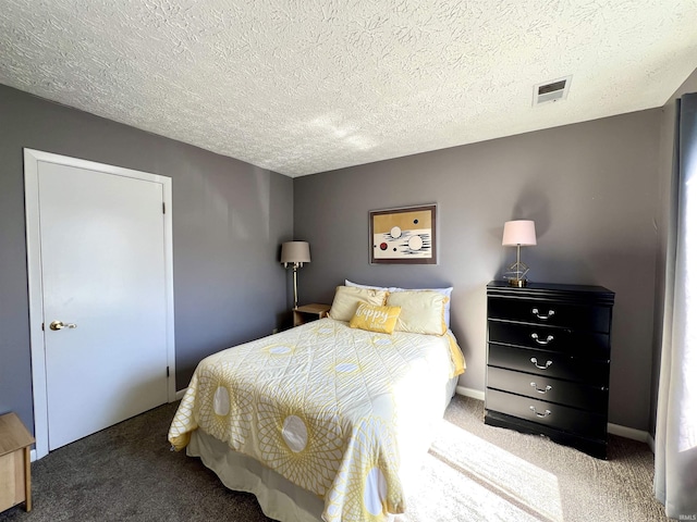 bedroom featuring visible vents, a textured ceiling, baseboards, and carpet floors