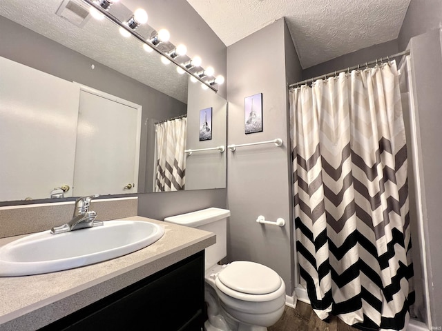 bathroom with vanity, a shower with shower curtain, visible vents, a textured ceiling, and toilet