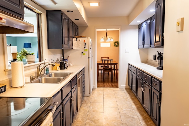 kitchen with light tile patterned flooring, light countertops, under cabinet range hood, and a sink