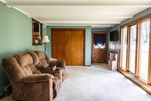 living room with beam ceiling, light carpet, and crown molding