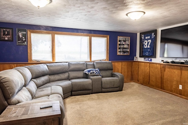 living area with carpet flooring, wooden walls, a textured ceiling, and wainscoting