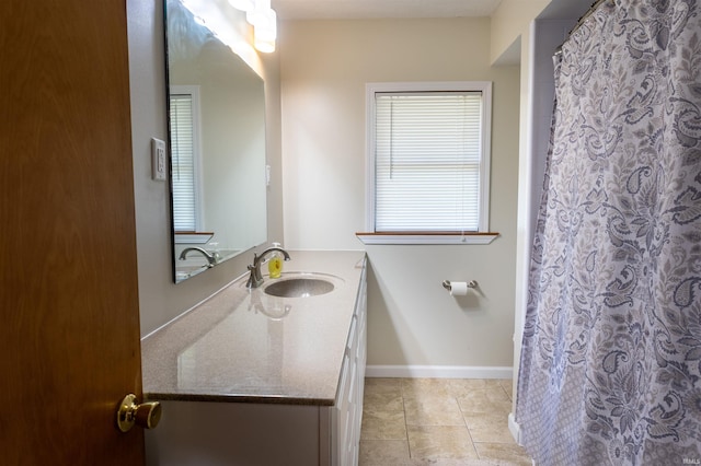 full bath featuring tile patterned floors, vanity, and baseboards