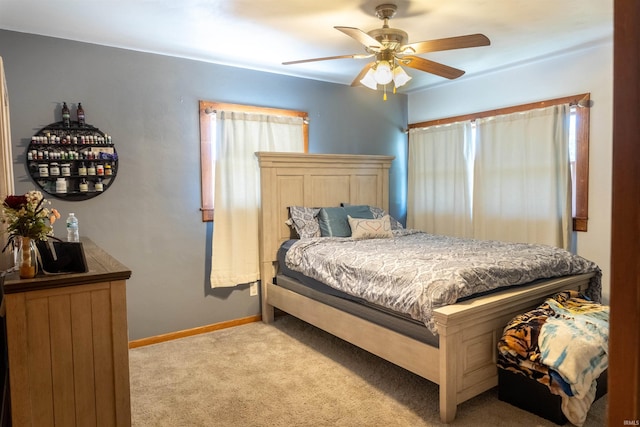 bedroom with light colored carpet, baseboards, and ceiling fan