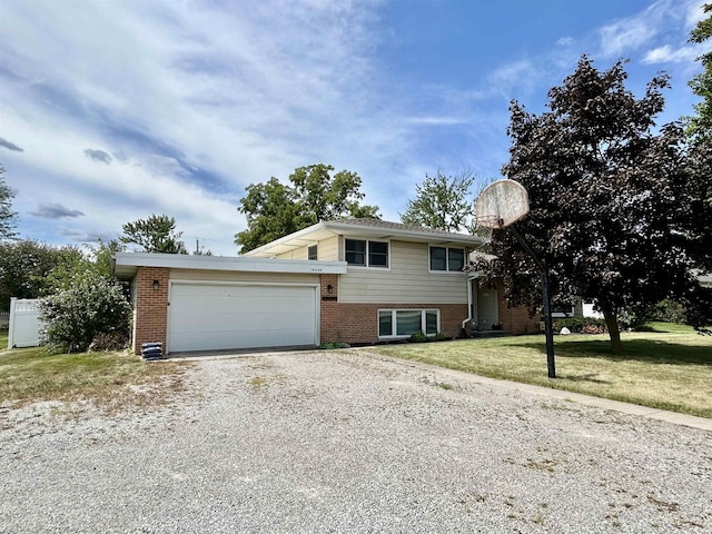 split level home with a front lawn, an attached garage, brick siding, and driveway