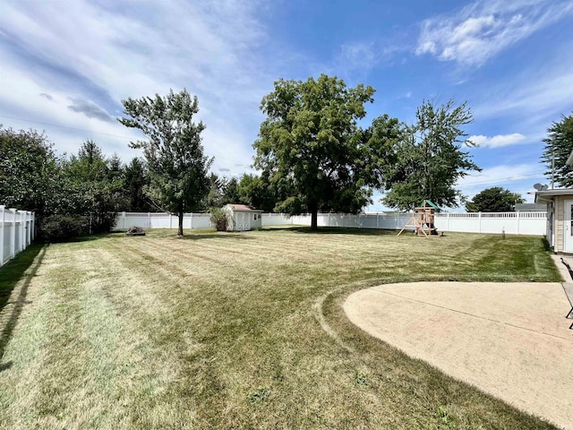 view of yard with an outdoor structure, a playground, and a fenced backyard