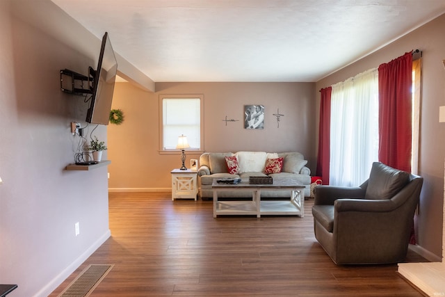 living area featuring dark wood finished floors, visible vents, and baseboards