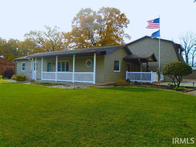 single story home with a porch and a front yard