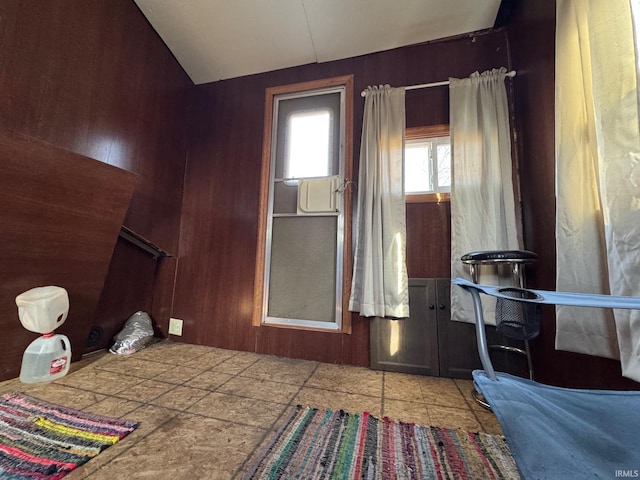 bedroom featuring wood walls and vaulted ceiling