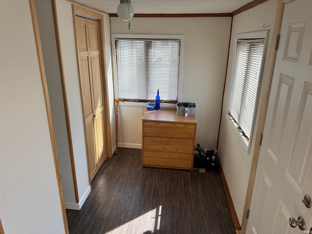 interior space with crown molding, dark wood-style floors, and baseboards