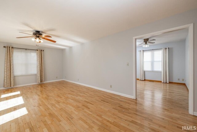 spare room featuring light wood-style flooring, baseboards, and ceiling fan