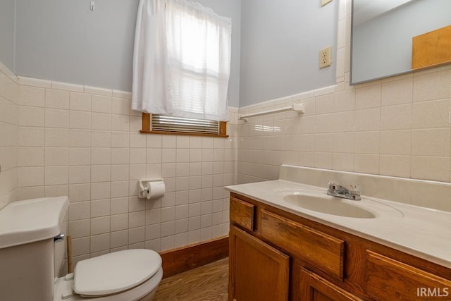 bathroom featuring tile walls, toilet, and vanity