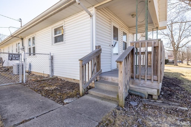 view of home's exterior featuring fence, central AC, and a gate