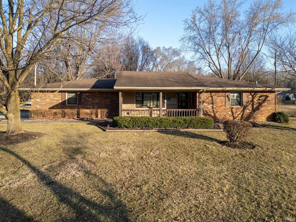 single story home with brick siding, a porch, and a front yard