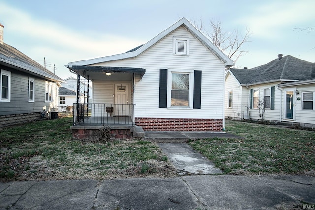 bungalow featuring cooling unit and a front yard